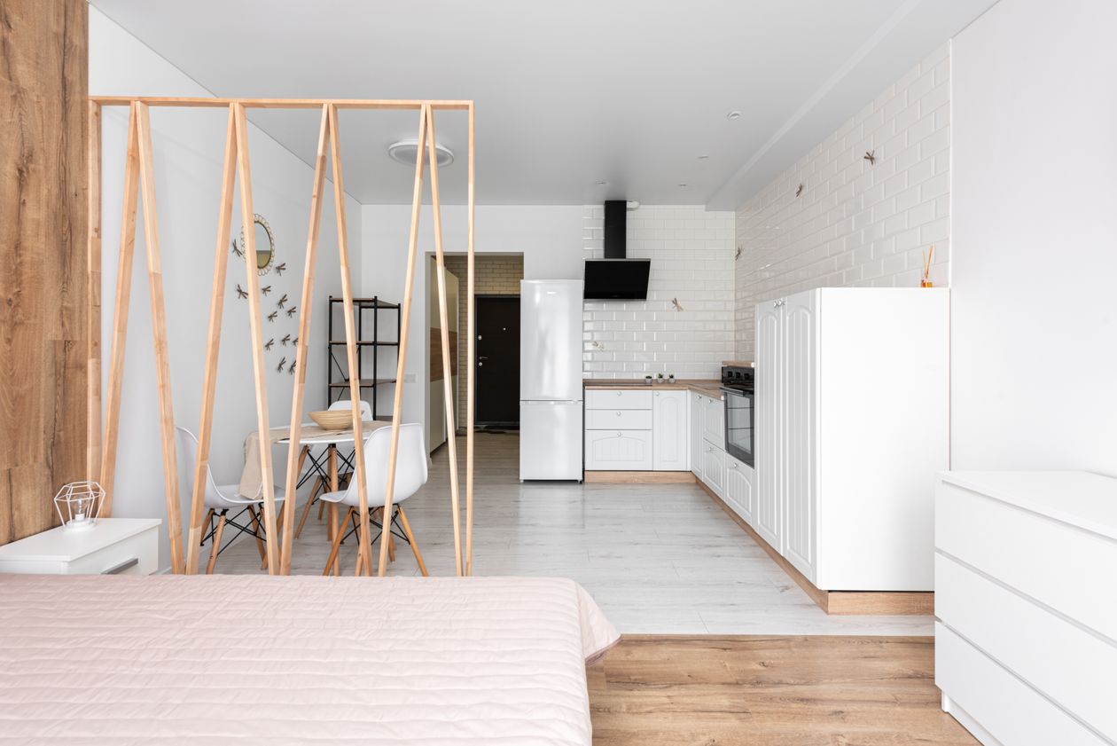 Studio apartment with open-plan bed, dining and kitchen zones, a small space storage and organization idea