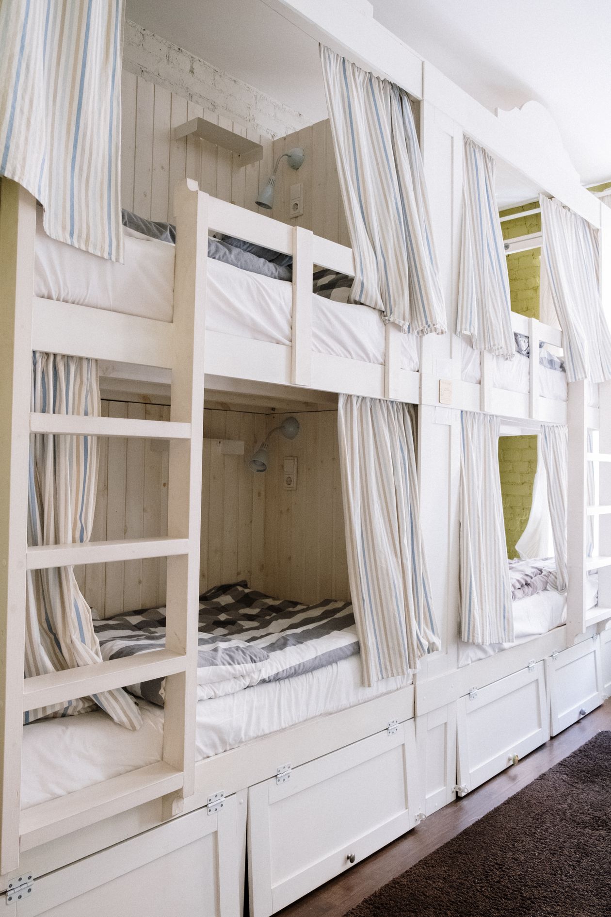 Bunk beds with curtained sleeping nooks and space underneath, an under bed storage and organization idea